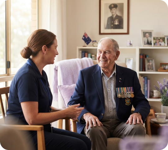 Carer chatting with a smiling veteran wearing his service medals at home