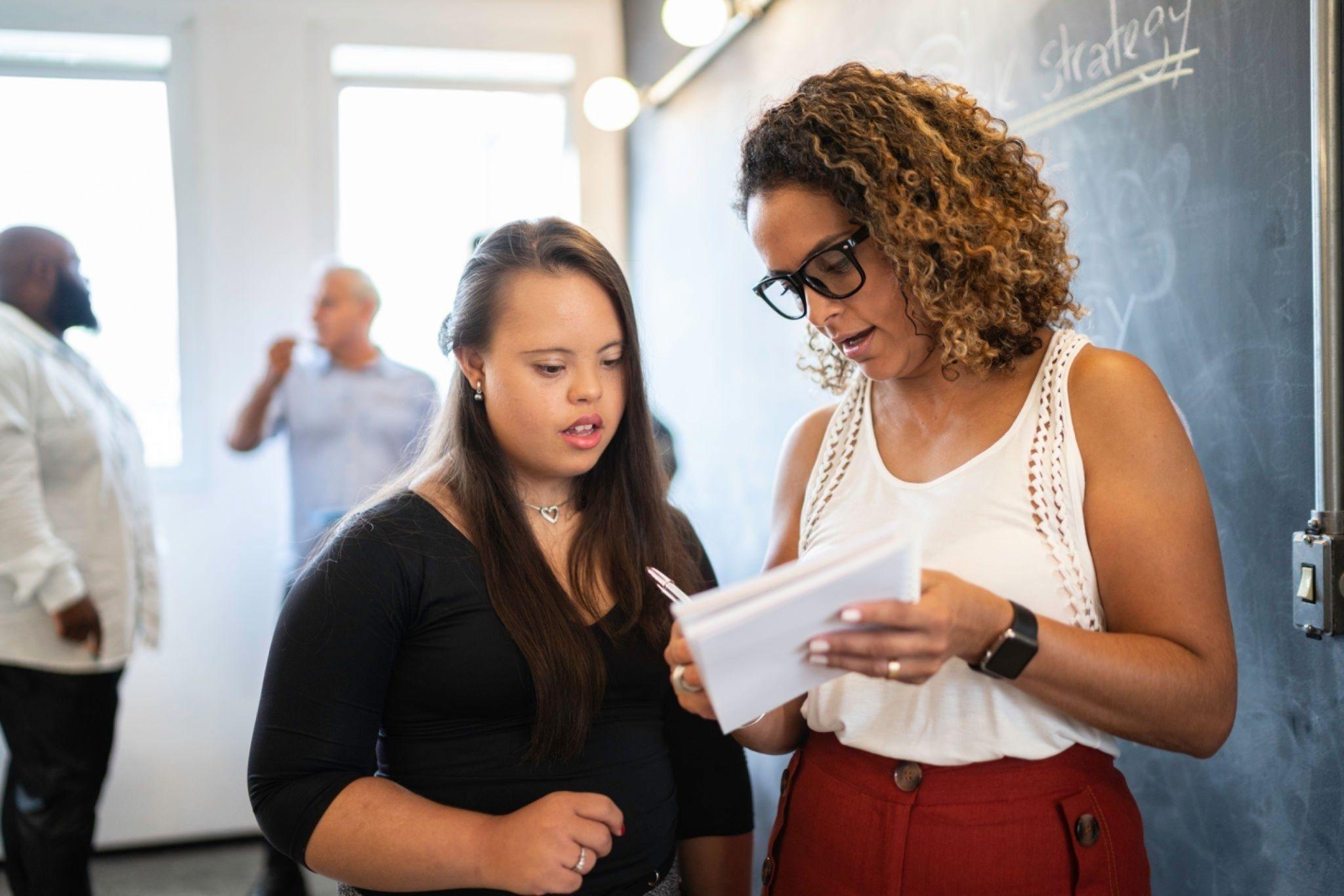 Support worker reading a document with a young woman