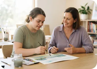 Support worker and young woman painting together at a table