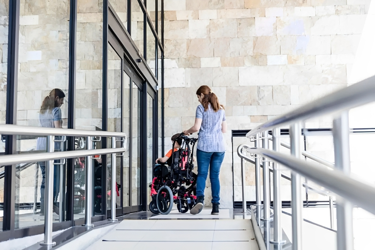 Carer walking with a participant along a walkway